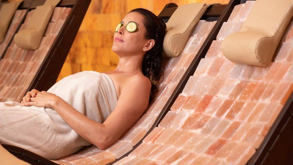 Margaritaville Resort Orlando's St. Somewhere Spa में स्पा उपचार के दौरान आराम करती महिला।