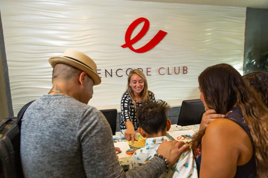 موظف بواب في Encore Resort في ريونيون يظهر لعائلة من الضيوف مواقع النشاط في جميع أنحاء المنتجع.