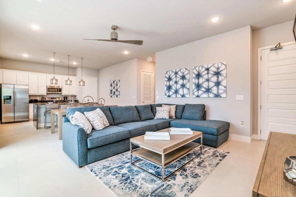 Gran salón amueblado, sala de estar, comedor y cocina combinados dentro de una casa de vacaciones en alquiler de Spectrum Resort Orlando.