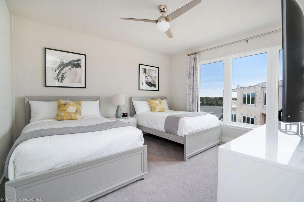 Dormitorio en suite amueblado con camas dobles completas dentro de una casa de vacaciones en alquiler de Spectrum Resort Orlando.