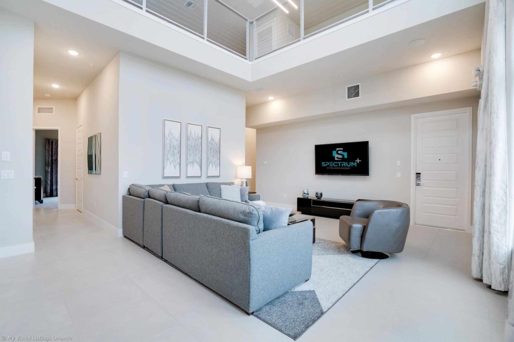 Sala de estar amueblada con altillo colgante dentro de una casa de vacaciones en alquiler de Spectrum Resort Orlando.