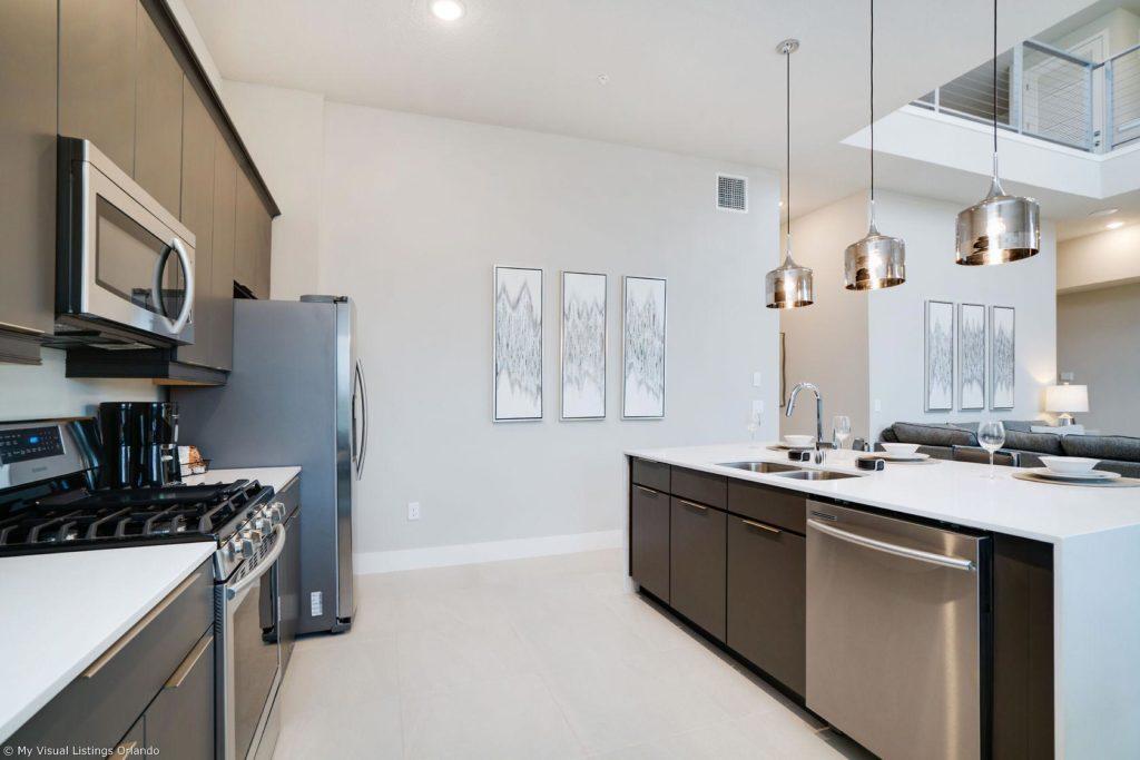 Furnished kitchen with island sink inside a Spectrum Resort Orlando vacation home rental.