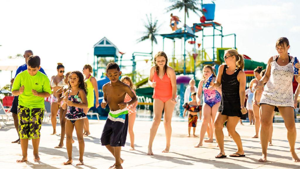 Group of kids and adults dancing to live music at the Encore Resort at Reunion water park.
