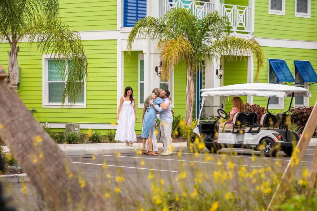 Menschen grüßen einander in einem privaten Cottage im Margaritaville Resort Orlando.