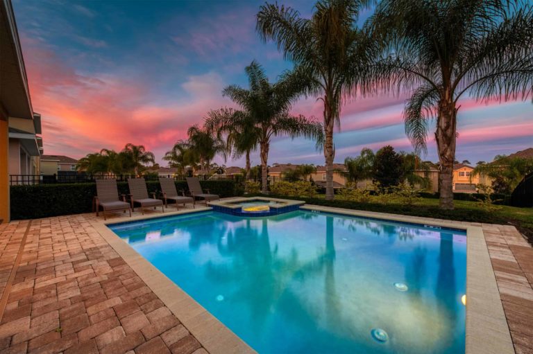 Lit backyard pool at sunset at an Encore Resort at Reunion curated resort residence.