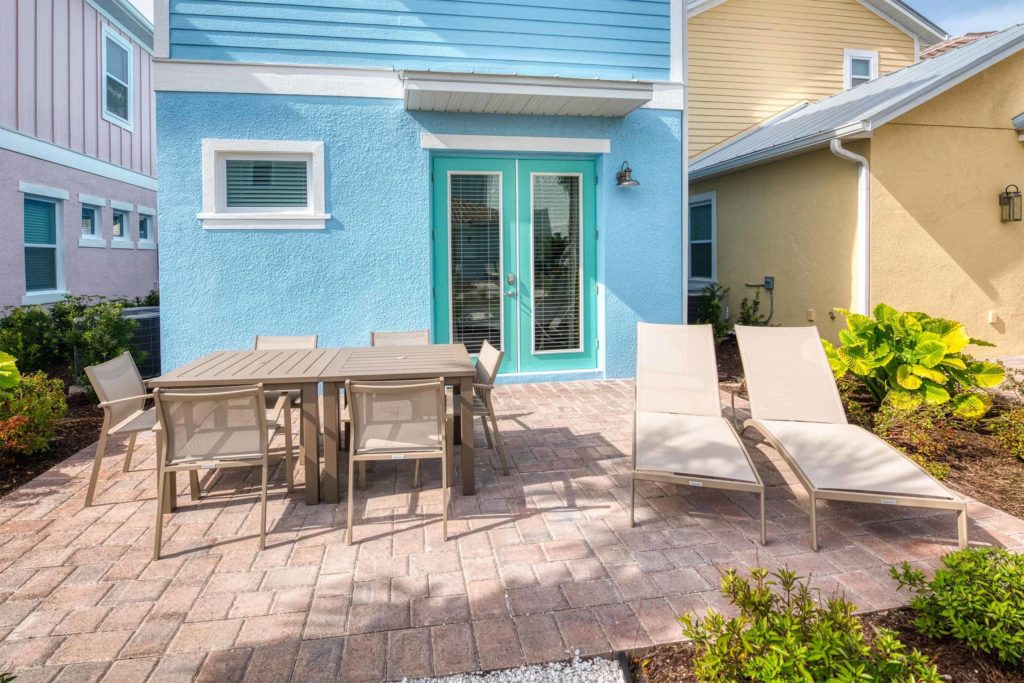 Patio de la cabaña privada de Margaritaville Resort Orlando con tumbonas y mesa de comedor