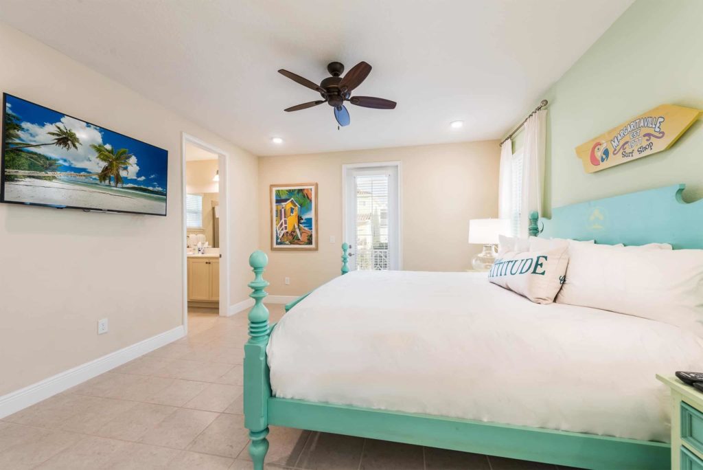 Dormitorio principal de la cabaña privada de Margaritaville Resort Orlando con TV montado en la pared