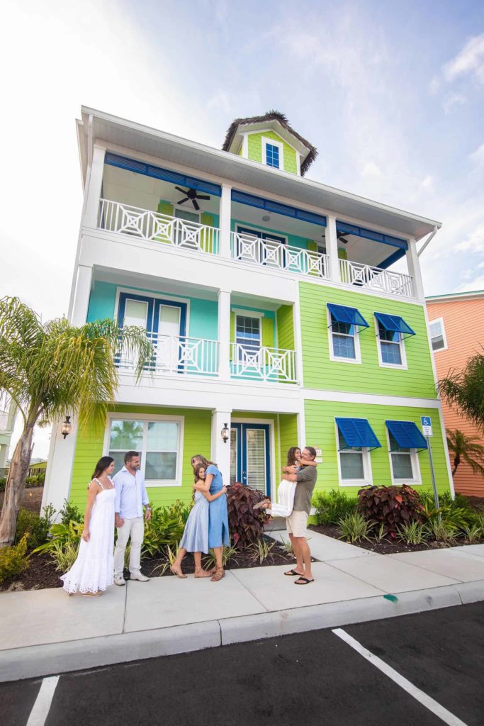 Familie begrüßt sich außerhalb eines privaten Cottages im Margaritaville Resort Orlando.