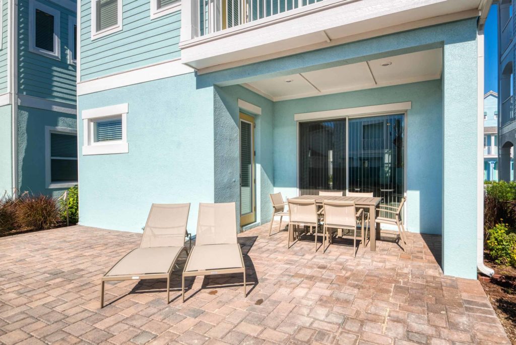 Patio al aire libre de la cabaña privada de Margaritaville Resort Orlando con tumbonas y mesa de comedor