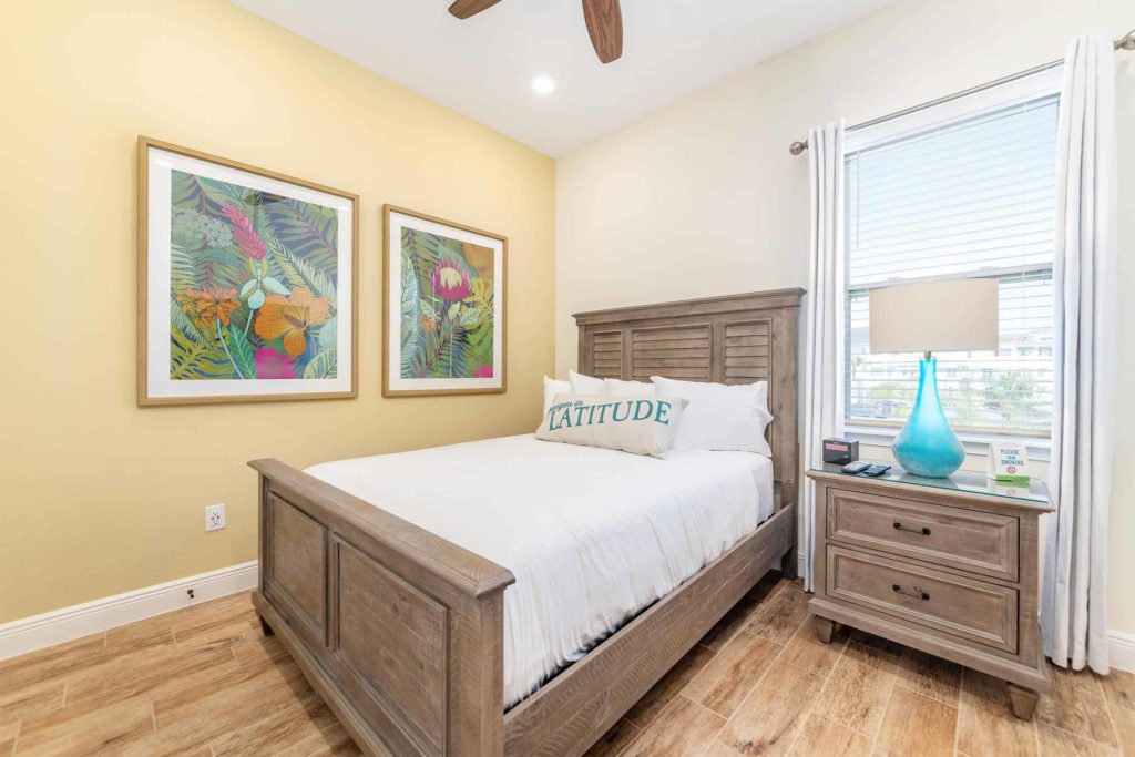 Dormitorio de la cabaña privada de Margaritaville Resort Orlando con arte tropical en la pared