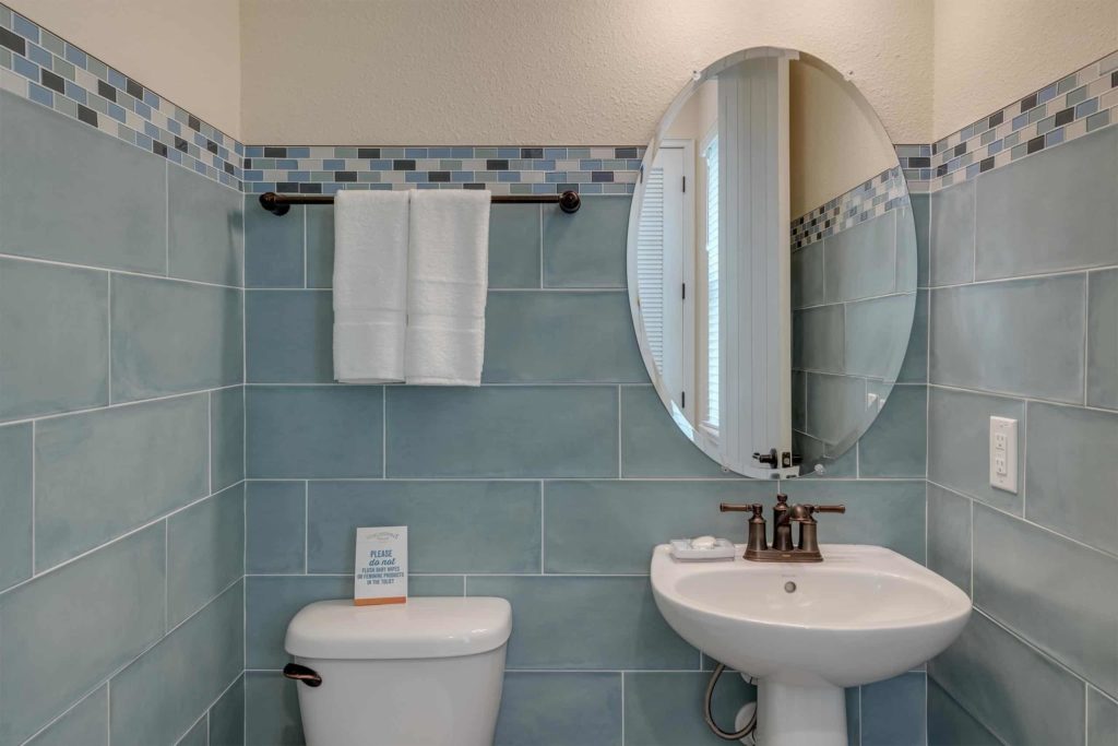 Medio baño de la cabaña privada de Margaritaville Resort Orlando con espejo de lavamanos grande