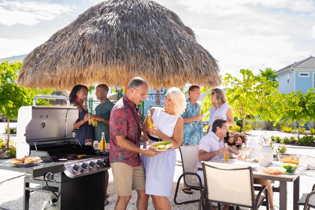 الأزواج الذين يطبخون بالخارج في منزل ريفي خاص في Margaritaville Resort Orlando.