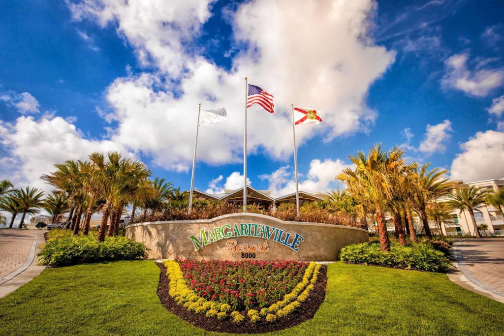 Señal de entrada frontal de Margaritaville Resort Orlando con banderas de los EE. UU., Florida y Margaritaville.