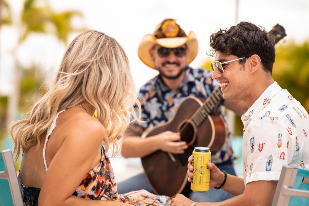 عازف الجيتار يعزف لزوجين في Margaritaville Resort Orlandoo Salty Rim Bar and Grill.