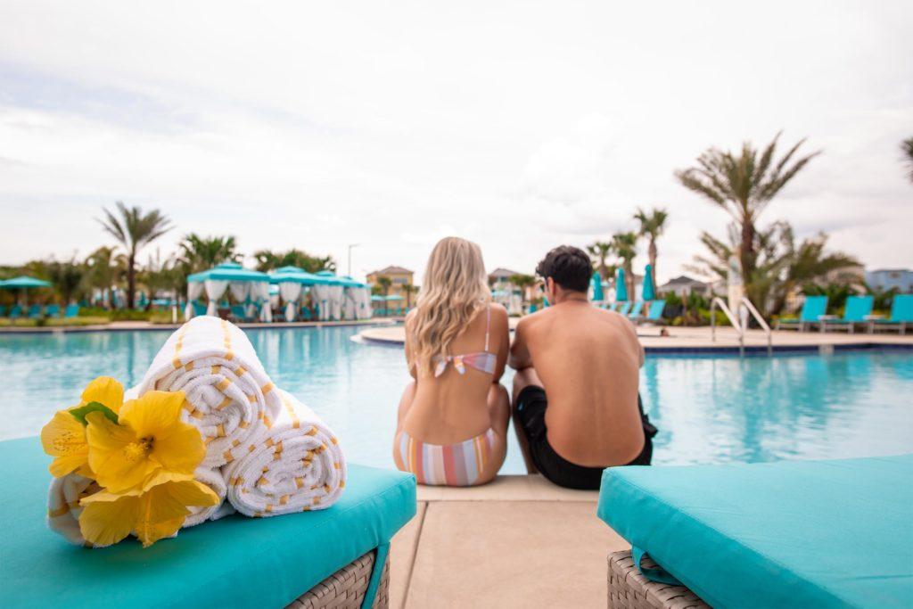 زوجان يجلسان بجوار مسبح Margaritaville Resort Orlando Fins Up