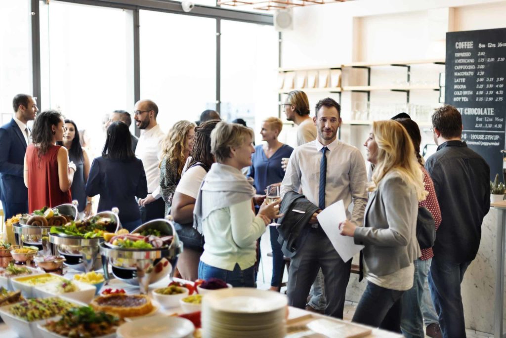 Large group of people mingling at a catered event.