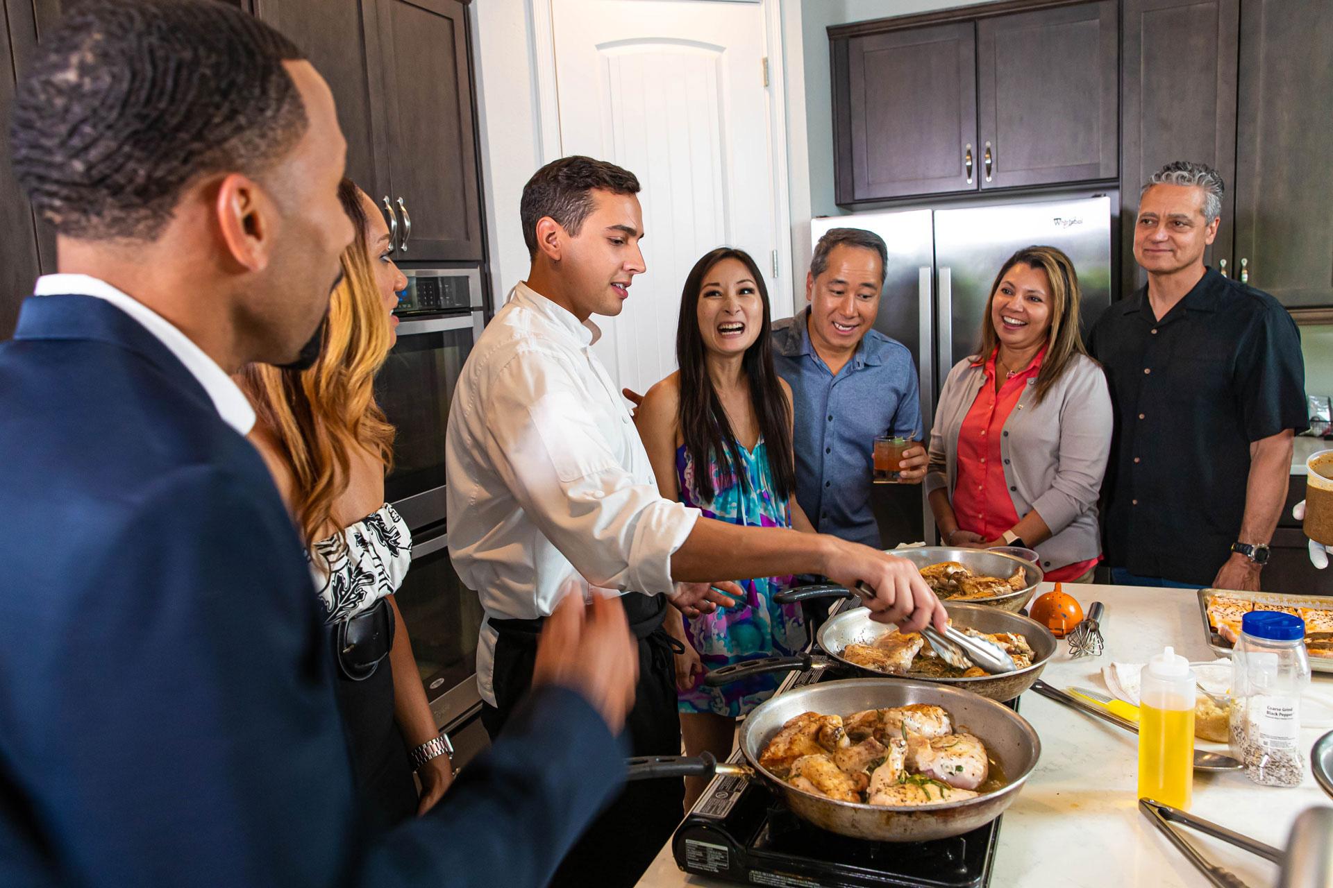 An expert chef cooks for a group during an in-home Chef Experience at a Rentyl Resorts curated resort residence.