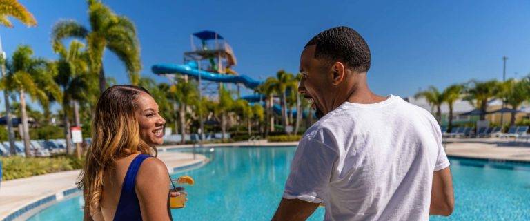 Couple holding hands next to the Encore Resort at Reunion water park pool.