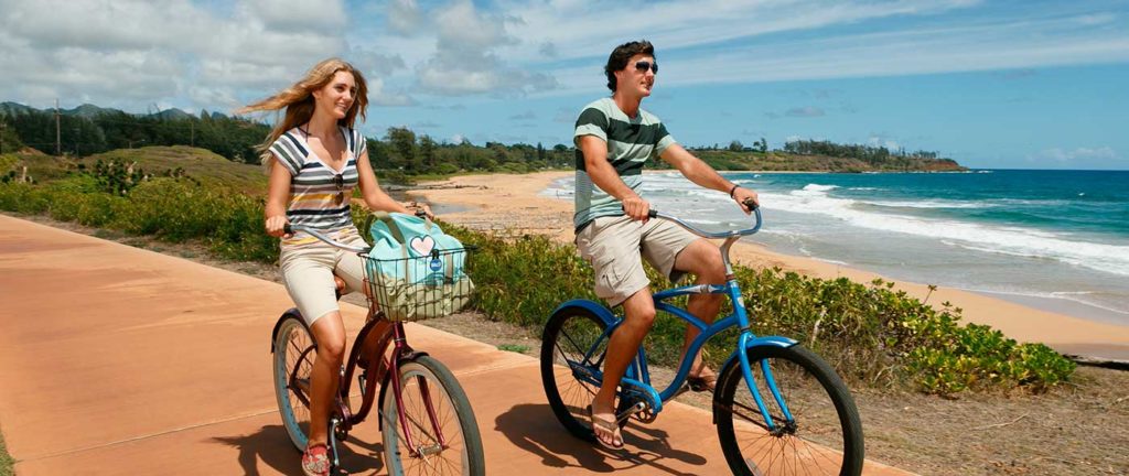 زوجان يركبان دراجات في كاواي ، هاواي بالقرب من منتجع بونو كاي.