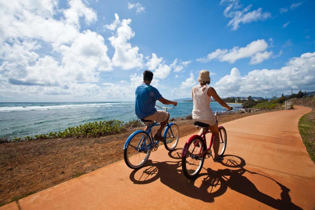 زوجان يركبان الدراجات على مسار الدراجات في منتجع Pono Kai.