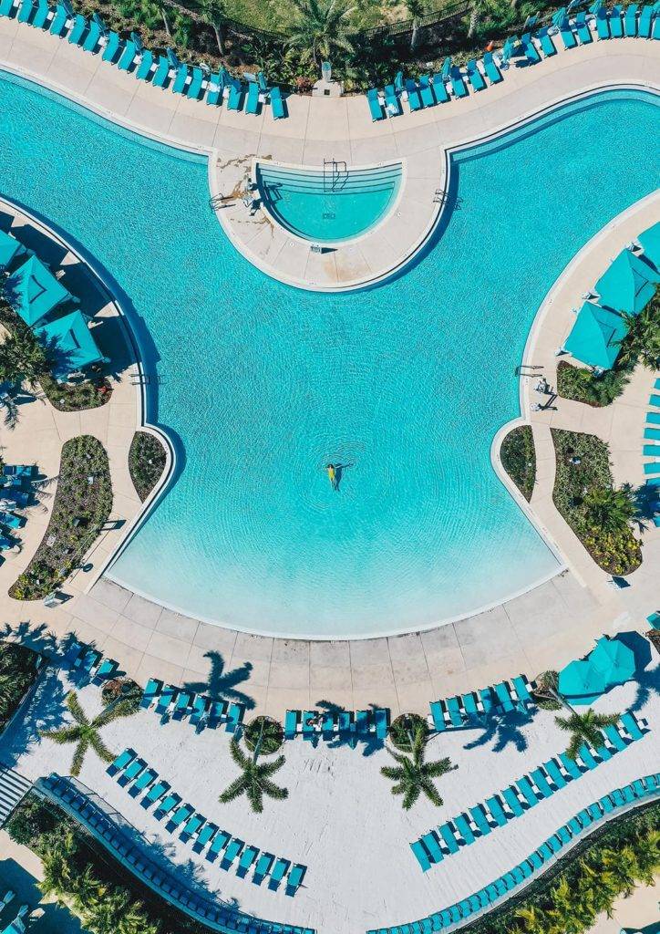 Vista aérea de una mujer flotando sola en la piscina Fins Up en Margaritaville Resort Orlando.