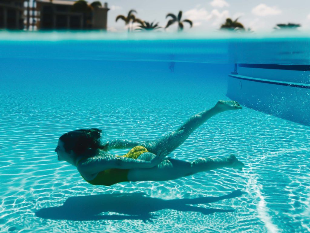 Woman swimming underwater in the Margaritaville Resort Orlando Fins Up Pool.