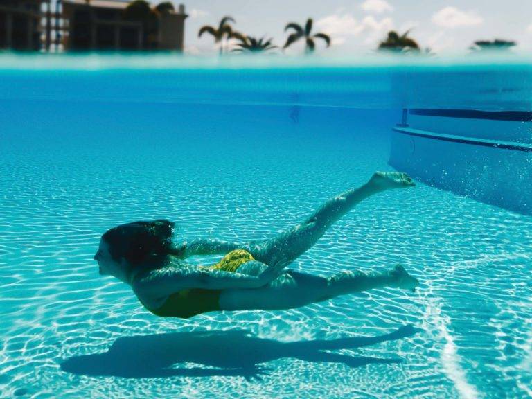 Woman swimming underwater in the Margaritaville Resort Orlando Fins Up Pool.