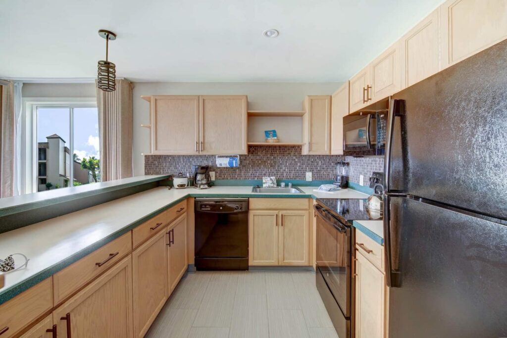 Full kitchen with oven range, dishwasher, and refrigerator at Pono Kai Resort