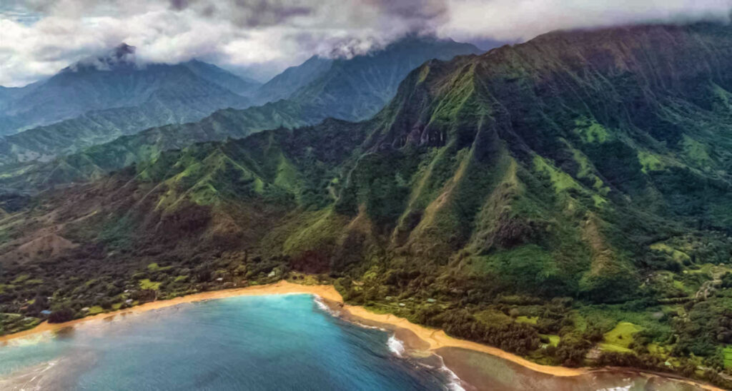 Aerial view of the island of Kauai, Hawaii, with beach and mountains.