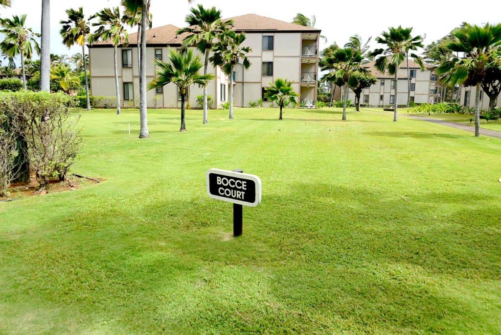 Amplia cancha de bochas rodeada de palmeras en Pono Kai Resort.
