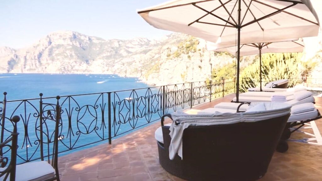 Asientos bajo sombrillas con vistas al mar Tirreno y la costa de Amalfi desde Villa Lilly.