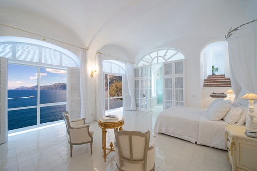 Amplio dormitorio en Villa Lilly con grandes ventanales con vistas al mar Tirreno y la costa de Amalfi.