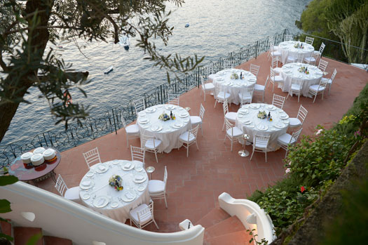 Mesas puestas para un evento privado en el balcón exterior de Villa Lilly.