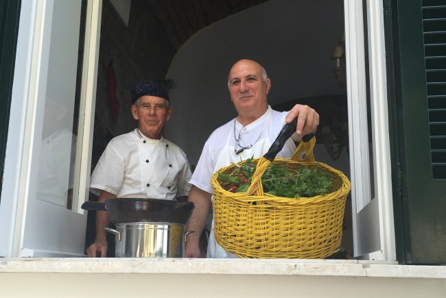 Chefs en el lugar con canastas de verduras en Villa Lilly.