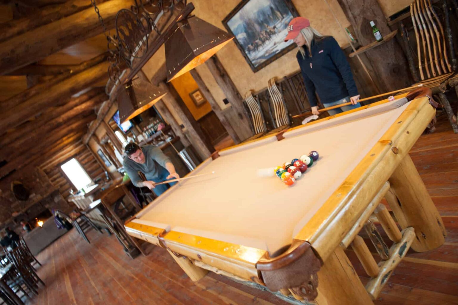 Couple playing pool inside the Ranches at Belt Creek clubhouse.