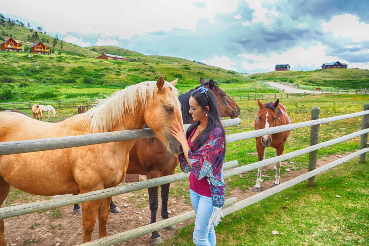 Woman petting a horse at The Ranches at Belt Creek’s equestrian facilities.