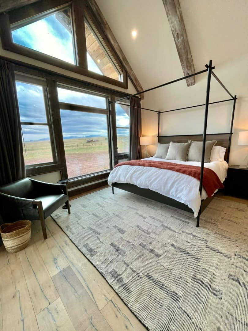 Lucky Man Ranch bedroom with large windows and four poster bed