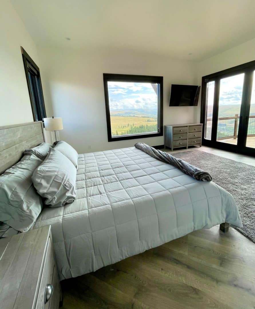 Sunset Ranch bedroom with large mountain view windows and outdoor porch access