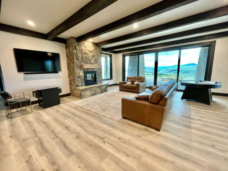 Sunset Ranch game room with stone fireplace, gaming tables, and wall mounted TV