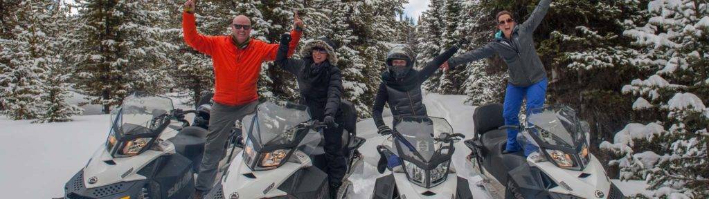 Group of people riding snowmobiles at The Ranches at Belt Creek.