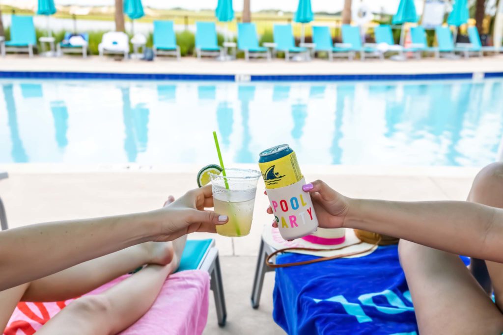 Hände klirren mit tropischen Getränken neben dem Fins Up Pool im Margaritaville Resort Orlando.