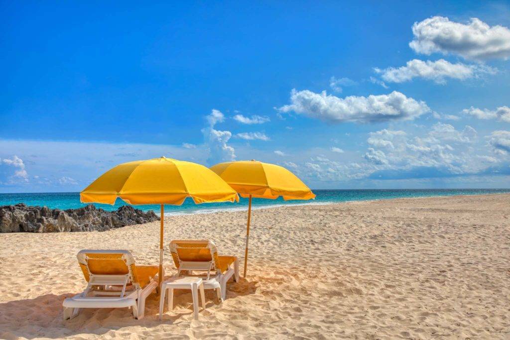 Tumbonas bajo sombrillas en la playa de Bermudas en Newstead Belmont Hills Golf Resort and Spa.