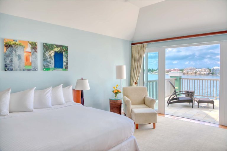 Suite del complejo Newstead Belmont Hills con cama King grande y balcón con vista al mar.