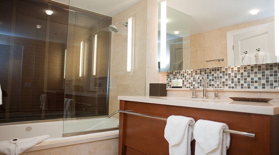 Baño de la suite Studio Deluxe con bañera y ducha con puerta de cristal