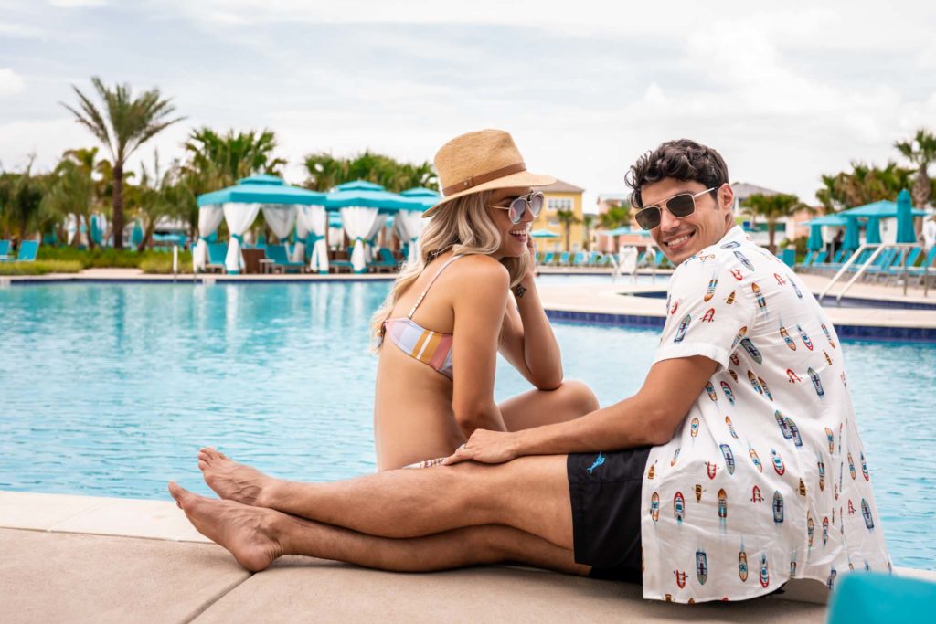 زوجان يجلسان بجانب المسبح في Margaritaville Resort Orlando.