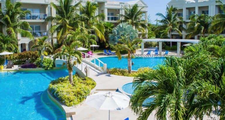 Las piscinas privadas del Atrium Resort rodeadas de palmeras y jardines tropicales.