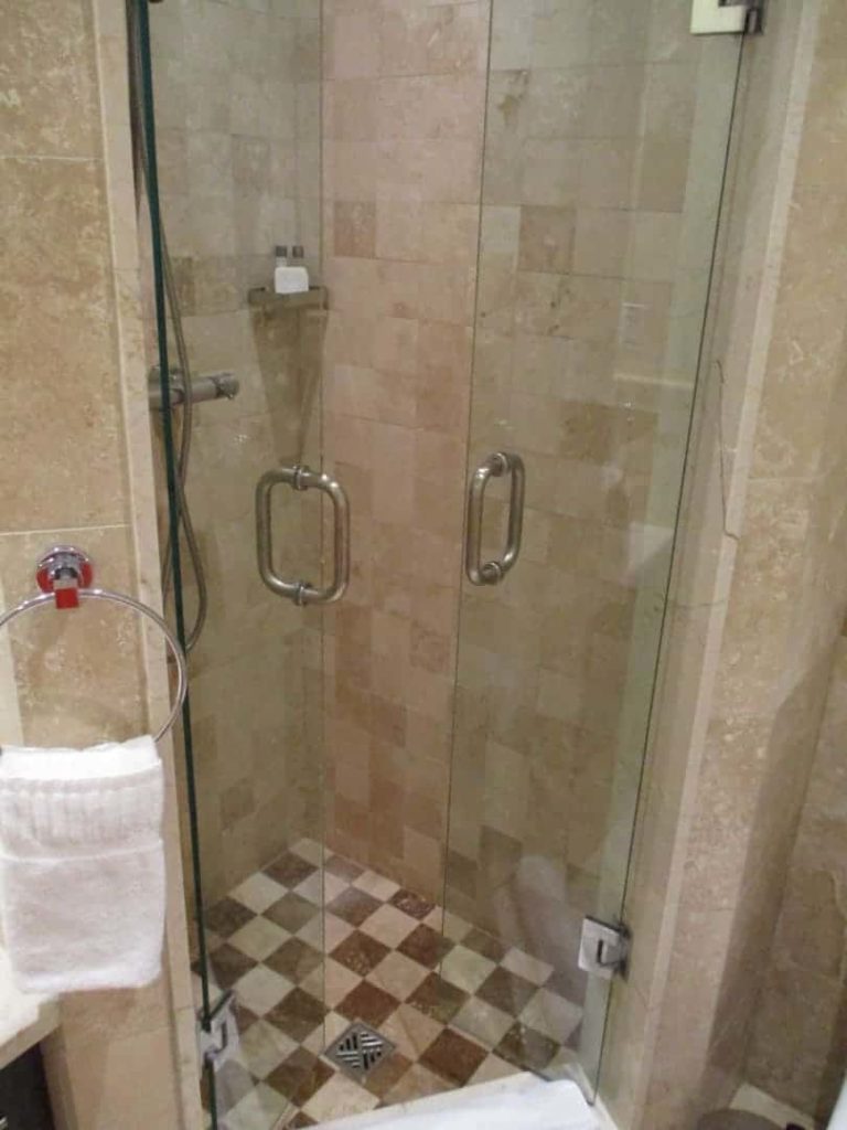 Studio suite bathroom with standing shower stall at The Atrium Resort.