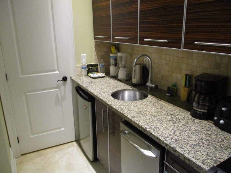 Cocina con lavavajillas y mini refrigerador en una suite estudio en The Atrium Resort.