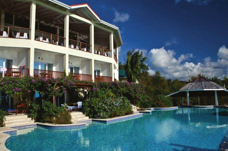 La piscina frente al mar de Calabash Cove, las suites junior en la piscina y el restaurante Windsong.