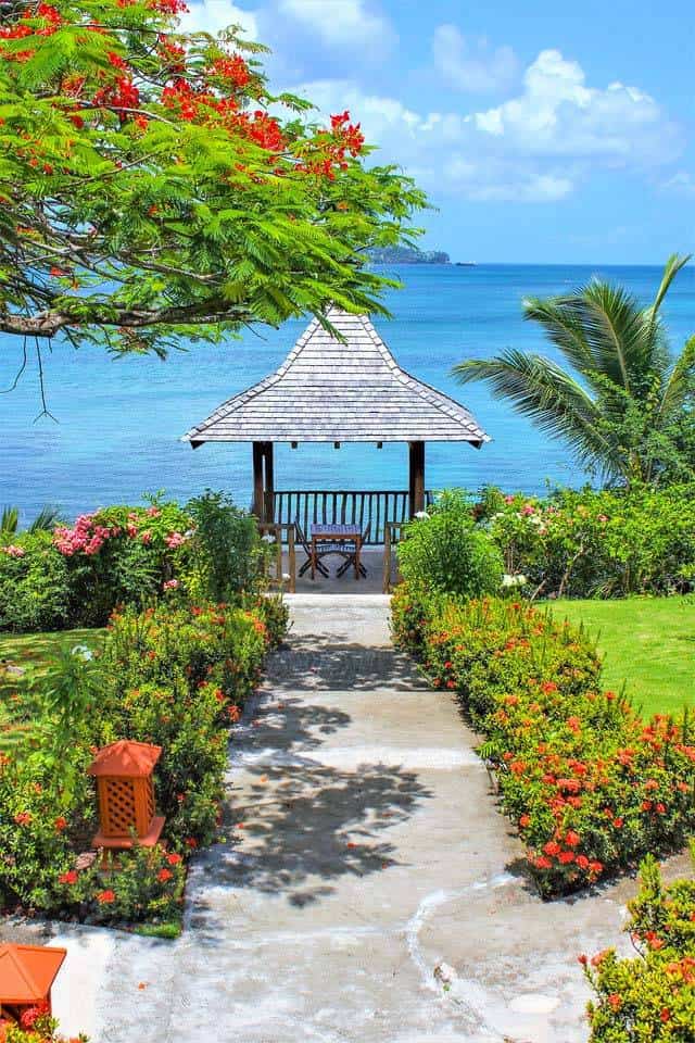 Calabash Cove 的婚礼凉亭半悬在加勒比海的边缘，周围环绕着盛开的美景。